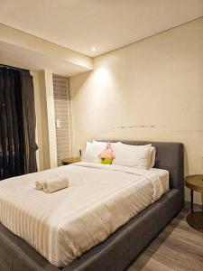 a bedroom with a large bed with a stuffed animal on it at Aksara de jivva at Pakuwon indah Cluster in Surabaya