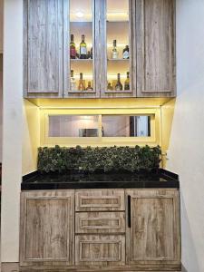 a kitchen with wooden cabinets and green plants on the counter at Aksara de jivva at Pakuwon indah Cluster in Surabaya