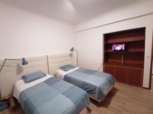 a bedroom with two beds and a tv in it at River City House 