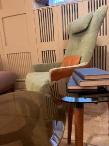 a living room with a chair and a table with books at Hotel Nizza in Florence