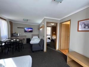 a hotel room with a bed and a dining room at Eaglehawk Motel Bendigo in Bendigo