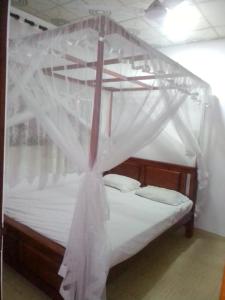 a bedroom with a bed with a mosquito net at VA Villa Hikkaduwa in Hikkaduwa