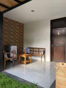een patio met een bank en een houten deur bij The Friz Arimanu in Kuta
