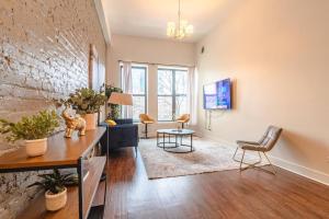 una sala de estar de planta abierta con una pared de ladrillo en McCormick Place 420 friendly 3BR/2BA with Optional parking for up to 8 guests en Chicago