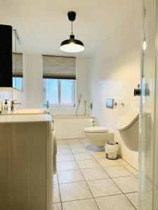 ein Badezimmer mit einer Badewanne, einem Waschbecken und einem WC in der Unterkunft Geräumiges Wohnen auf 125m2 für 6 Personen in Wolfsburg