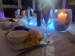 stół ze świecą i talerzami jedzenia i frytek w obiekcie 51 On Vlei w Kapsztadzie