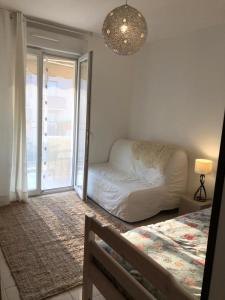 a living room with a white couch and a window at Plein centre de Beaulieu in Beaulieu-sur-Mer