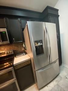 a stainless steel refrigerator in a kitchen next to a stove at Elegant Parisian Home near Fondren in Jackson
