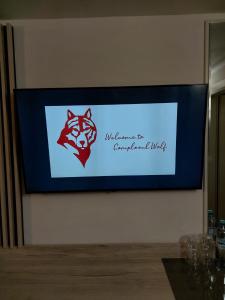 un televisor con un logotipo de lobo en una pared en Hotel Wolf 2, en Bran