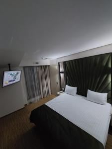 a hotel room with a large bed and a tv at Hotel Wolf 2 in Bran