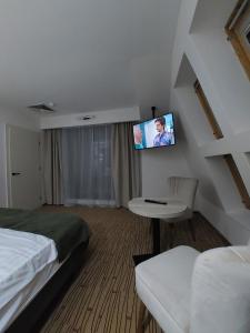 Habitación de hotel con cama y TV en la pared en Hotel Wolf 2, en Bran