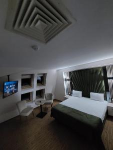 a bedroom with a bed and a flat screen tv at Hotel Wolf 2 in Bran
