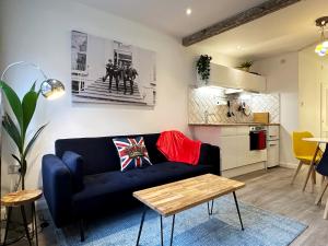 sala de estar con sofá azul y cocina en Kensington Studio hosted by AirOperate near Notting Hill - 1 Double Bed , 1 Sofa Bed, Ground Floor Apartment via Private Entrance en Londres