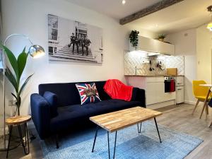 sala de estar con sofá azul y cocina en Kensington Studio hosted by AirOperate near Notting Hill - 1 Double Bed , 1 Sofa Bed, Ground Floor Apartment via Private Entrance en Londres