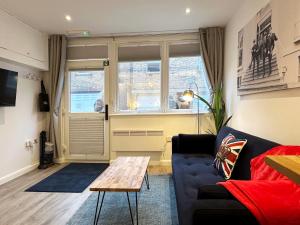 sala de estar con sofá y mesa en Kensington Studio hosted by AirOperate near Notting Hill - 1 Double Bed , 1 Sofa Bed, Ground Floor Apartment via Private Entrance en Londres