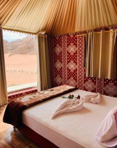 een bed in een kamer met uitzicht op een woestijn bij Lucas Camp Wadi Rum in Wadi Rum