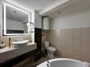 a bathroom with a tub and a sink and a toilet at Deribasivska 10 Luxury Apartment in Odesa +21 photos