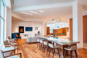 a kitchen and living room with a large table and chairs at Residence Inn by Marriott Boston Burlington in Burlington