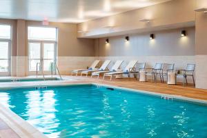 einen Pool in einem Hotelzimmer mit Stühlen in der Unterkunft Residence Inn by Marriott Boston Burlington in Burlington