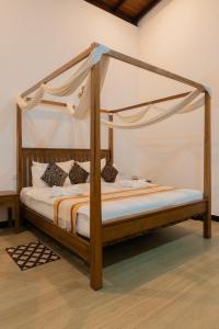 a bed with a wooden frame with a canopy at Radawana Wasala Nature Resort in Radawana