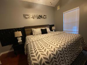 a bedroom with a bed with a black and white comforter at Elegant Parisian Home near Fondren in Jackson