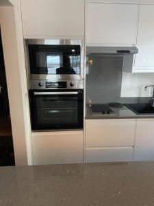 a kitchen with an oven and a microwave at Haus Residence Wohnungen ground floor 003 in Täsch