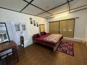 a bedroom with a bed in the corner of a room at Dreamwoods A travellers farmhouse in Dharamshala