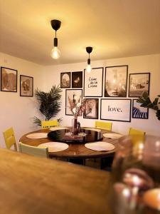 Slava Hygge House في ناكسكوف: غرفة طعام مع طاولات وصور على الحائط