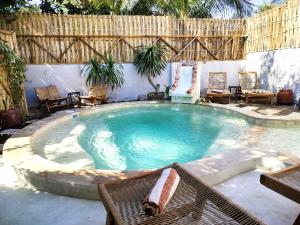 a large swimming pool with chairs and a table at Amel House in Gili Air