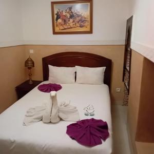 ein Bett mit Handtüchern und Schuhen darüber in der Unterkunft Dar Dadès in Marrakesch