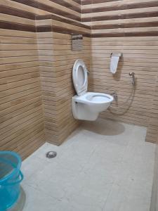 uma casa de banho com um WC e uma parede de madeira em KHUSHI HOTEL & RESTAURANT em Haldwani