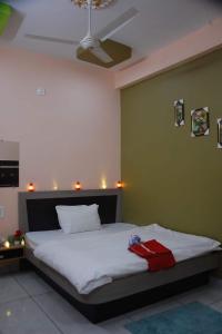 Un dormitorio con una cama blanca con una pared verde. en Hotel Adarsh Palace, en Maheshwar