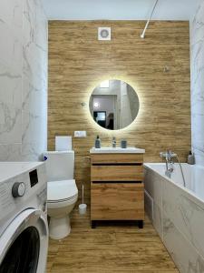 ein Badezimmer mit einem Waschbecken, einem WC und einem Spiegel in der Unterkunft Apartment for you in Iwano-Frankiwsk