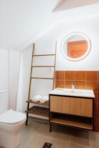 a bathroom with a toilet and a sink and a mirror at CANVAS Color Your Stay in Volos
