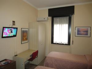 a bedroom with a bed and a tv on the wall at Hotel Europa in Sesto San Giovanni