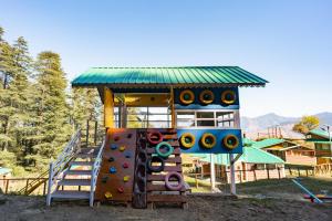 a playground with a slide and a play structure at Kanasar Jungle Camp & Retreat in Dehradun