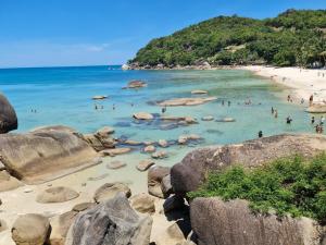 eine Gruppe von Menschen im Wasser an einem Strand in der Unterkunft SUhotel Suratthani in Surat Thani