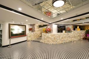 een lobby met een wachtruimte met een bank en bloemen bij Babeeni Family Hotel Sapa in Sa Pa