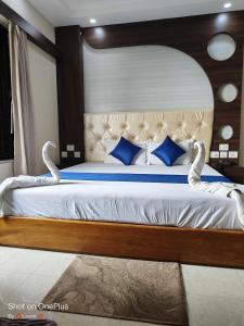 a bedroom with a large white bed with blue pillows at Hotel Rupasi Bangla 2, New Digha - Near Sea Beach in Digha