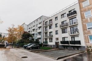 an apartment building with cars parked in a parking lot at Old Town city center apartment 1 - private parking included in Košice