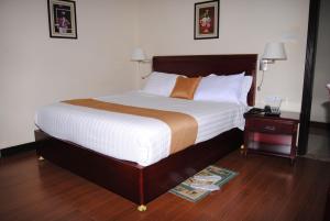 a large bed in a hotel room with a night stand at Yaredzema International Hotel in Āksum