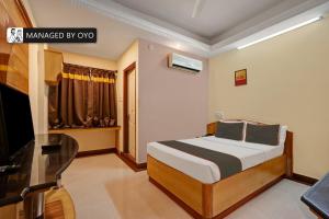 um quarto com uma cama e uma secretária num quarto em Super Collection O Bannerghatta Road Near IIM Bangalore em Bangalore