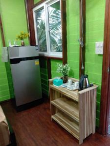 een keuken met groene muren en een koelkast bij Koh Mook Rem Ley in Trang
