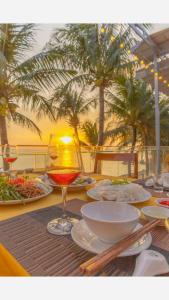 een tafel met borden en een glas wijn bij Victoria Phu Quoc hotel 1 minute walking to beach, near to night market in Phu Quoc
