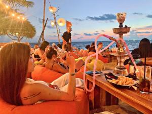 a group of people sitting around tables on the beach at Victoria Phu Quoc hotel 1 minute walking to beach, near to night market in Phu Quoc