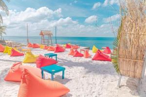 a beach with colorful chairs and tables on the sand at Victoria Phu Quoc hotel 1 minute walking to beach, near to night market in Phu Quoc