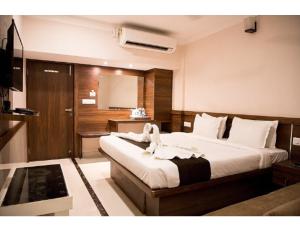 Habitación de hotel con cama y TV de pantalla plana. en Hotel Paras, Jabalpur, en Jabalpur