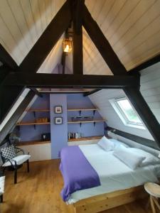 a attic bedroom with a bed and a window at Les Bernardies in Simeyrols