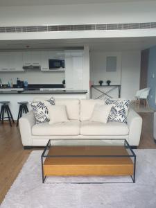 a living room with a white couch and a coffee table at Golf Lake Penthouse in As Sīfah