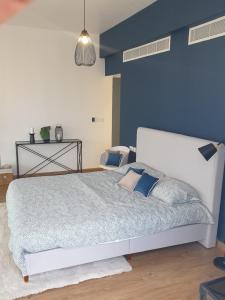 sypialnia z dużym łóżkiem z niebieską ścianą w obiekcie Golf Lake Penthouse w mieście As Sifah